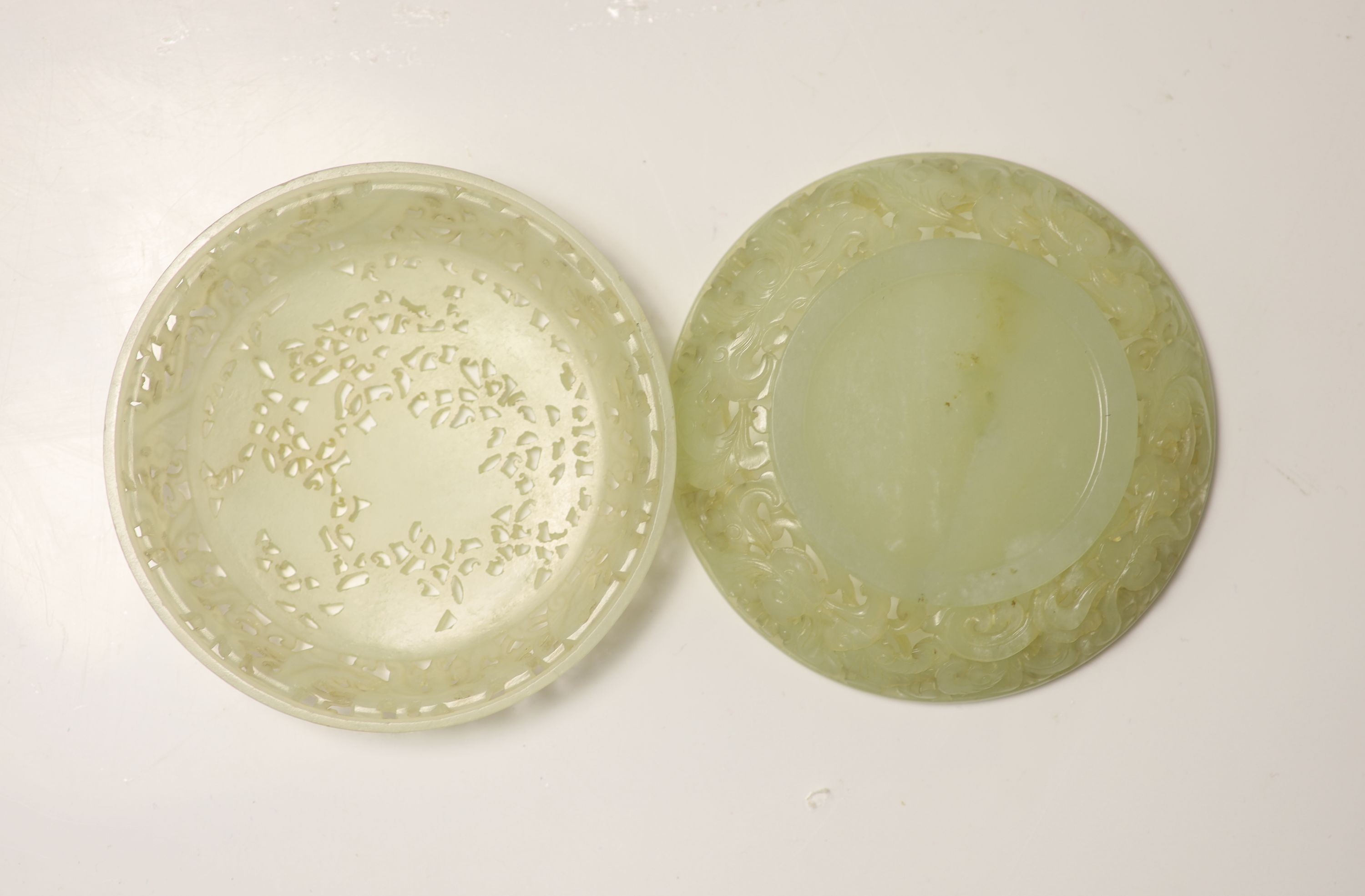 A fine Chinese pale celadon jade reticulated box and cover, 18th century, 9cm diameter, wood stand